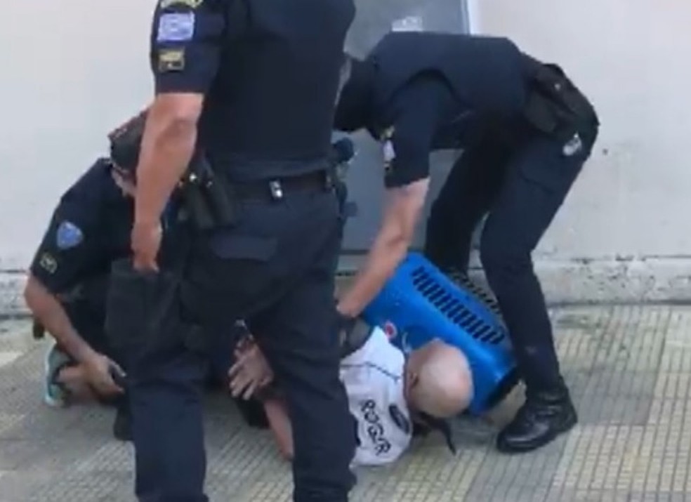 Morador de rua com camisa do Corinthians imobilizado por guardas civis em São José dos Campos — Foto: Reprodução