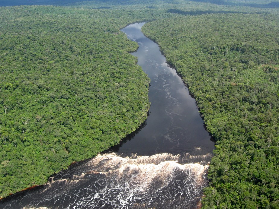 Um dos inúmeros rios tropicais que serpenteiam pelo coração da selva amazônica e desembocam em uma cachoeira