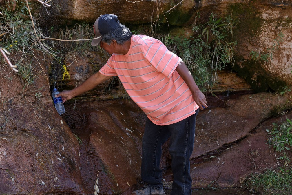 Glen John, de 65 anos, pega água em uma fonte natural em Bodaway Chapter, no território do povo Navajo — Foto: Stephanie Keith/Reuters