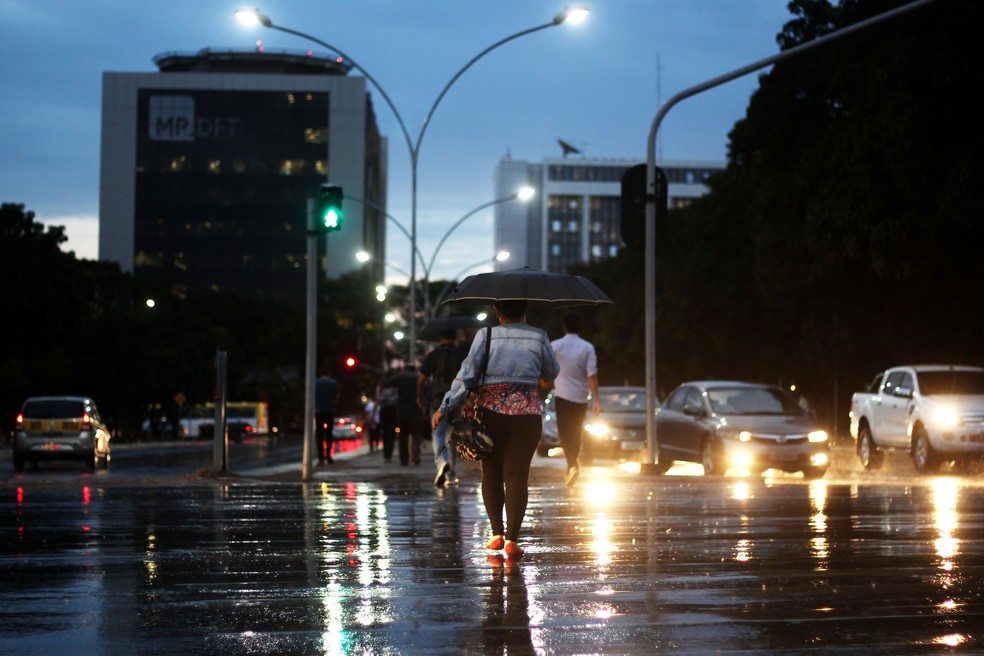 Mulher atravessa rua com guarda-chuva no centro de Brasília, em imagem de arquivo — Foto: Nilson Carvalho/Agência Brasília/Divulgação