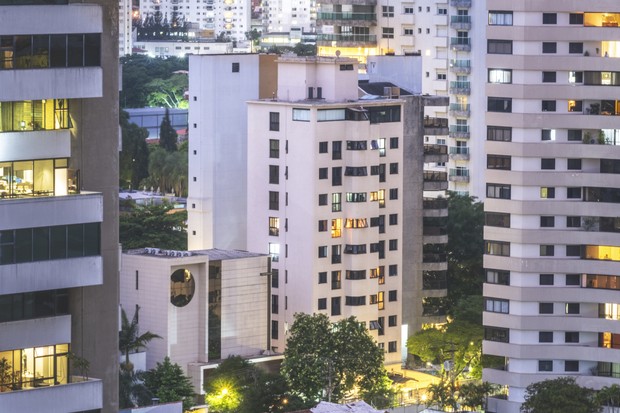 Skyline cityscape view of residential apartment blocks in a neighborhood of Sao Paulo, Brazil. Illuminated windows, communal gardens. No people. (Foto: Getty Images)