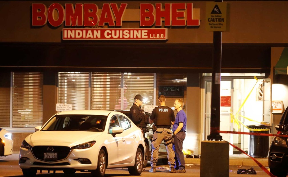 Policiais em frente ao restaurante onde dois homens detonaram uma bomba (Foto: Mark Blinch / Reuters)