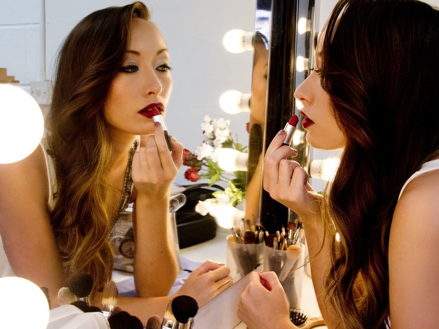 Mulher se olha no espelho ao passar batom  (Foto: Terri Lee/Shield Photography)