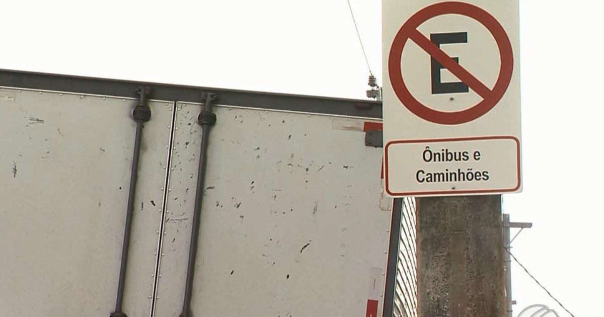 Um ônibus em uma garagem escura com uma placa que diz 'proibido