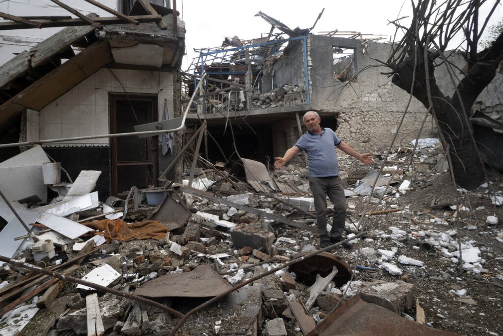 Homem vê casa ser destruída em confrontos entre militares pró-Armênia e forças do Azerbaijão em Stepanakert, maior cidade de Nagorno-Karabakh, nesta sexta (9) — Foto: AP Photo