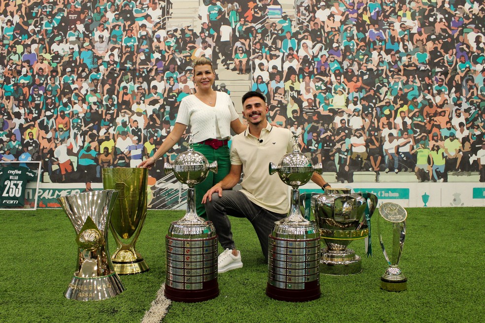 Willian e a esposa com os troféus que o jogador conquistou no Palmeiras — Foto: Divulgação