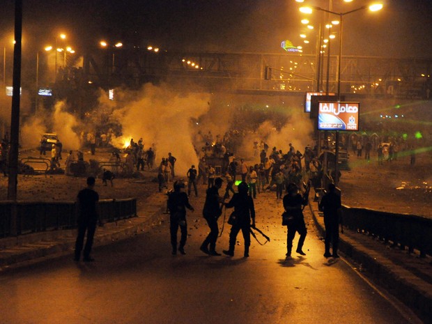 Grupo pró-Morsi (de costas) enfrenta a polícia no Cairo neste sábado (27). (Foto: AFP)