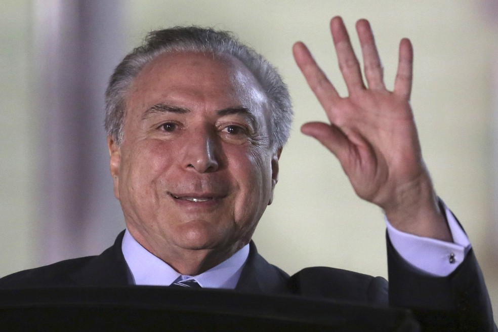 O presidente Michel Temer acena para a imprensa, em imagem de outubro (Foto: Eraldo Peres/AP)