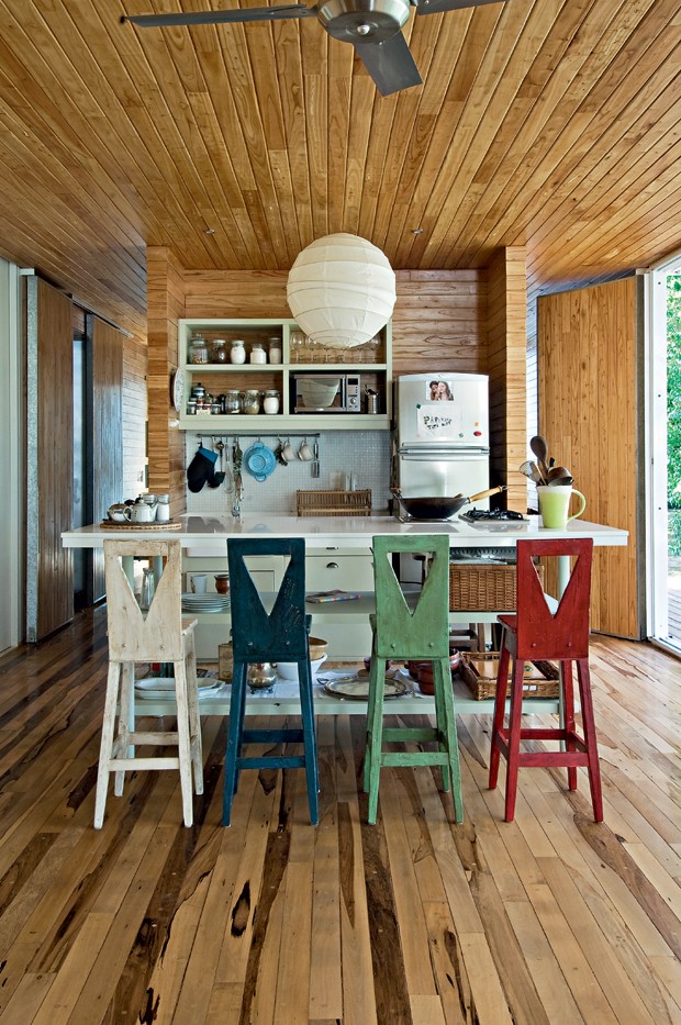 Cozinha compacta | Para aquecer os interiores, teto, piso, paredes e até as portas foramrevestidos com réguas de madeira tratada (Foto: Divulgação)
