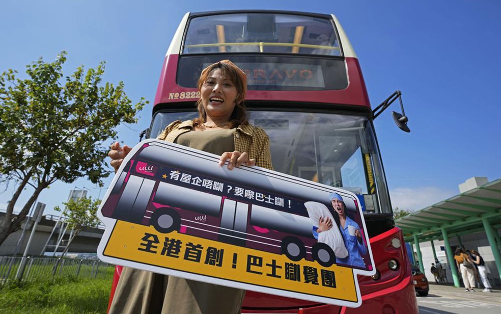 Passageira posa ao embarcar em ônibus para tour por Hong Kong, no sábado (16) — Foto: AP Photo/Kin Cheung