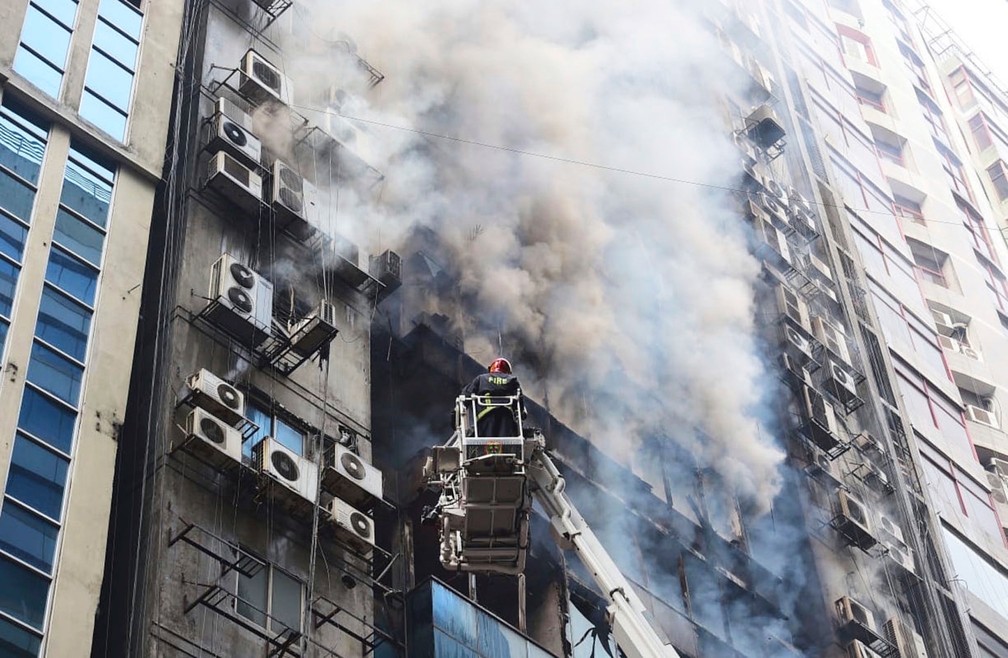 Bombeiros trabalham para conter incêndio em prédio comercial em Daca, em Bangladesh, nesta quinta-feira (28)  — Foto: Mahmud Hossain Opu/ AP
