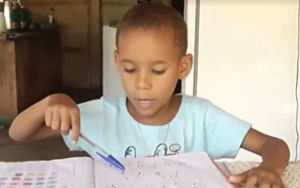 Thalys Malaquias, 5 anos, faz as tarefas em casa após subir morro para pegar sinal de internet — Foto: Reprodução/TV Anhanguera