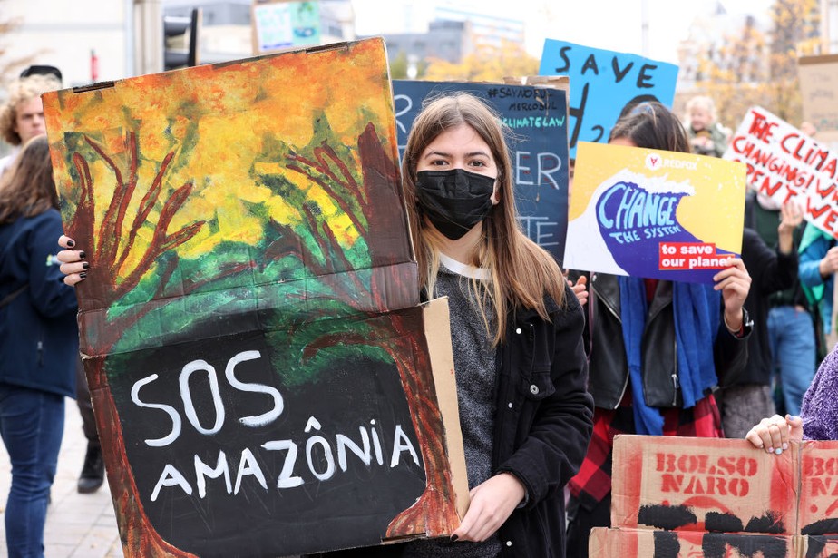 Ativistas seguram cartazes durante marcha em Bruxelas, na Bélgica, organizada pela 'Rise For Climate Belgium' para aumentar a conscientização sobre as mudanças climáticas após o início da COP26, em 31 de outubro de 2021