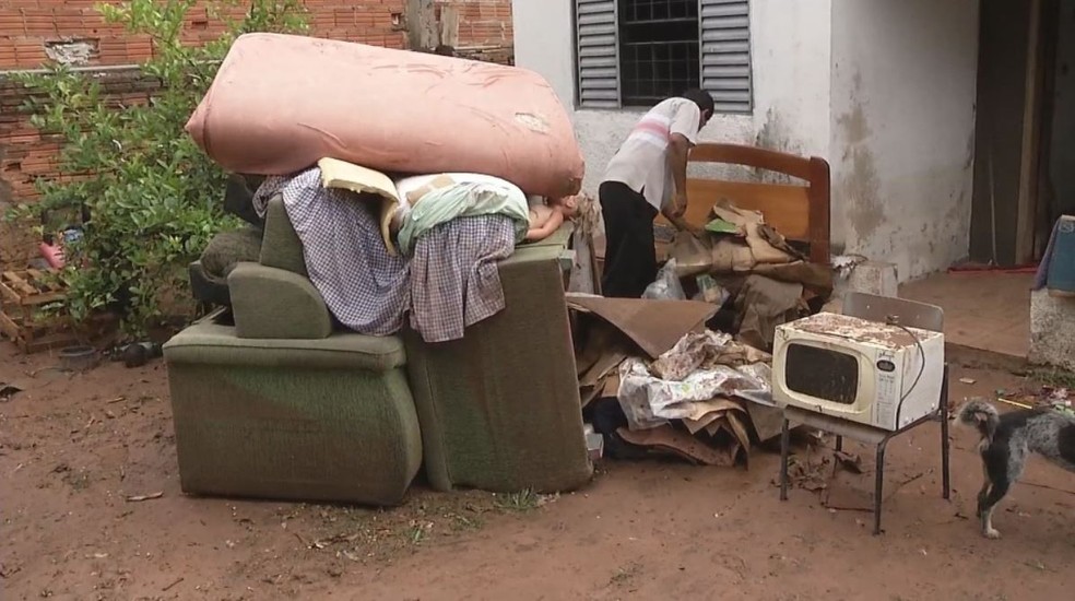 Moradores de Valparaíso (SP) que tiveram casas alagadas tentaram recuperar móveis atingidos pela enchente (Foto: Reprodução/TV TEM)