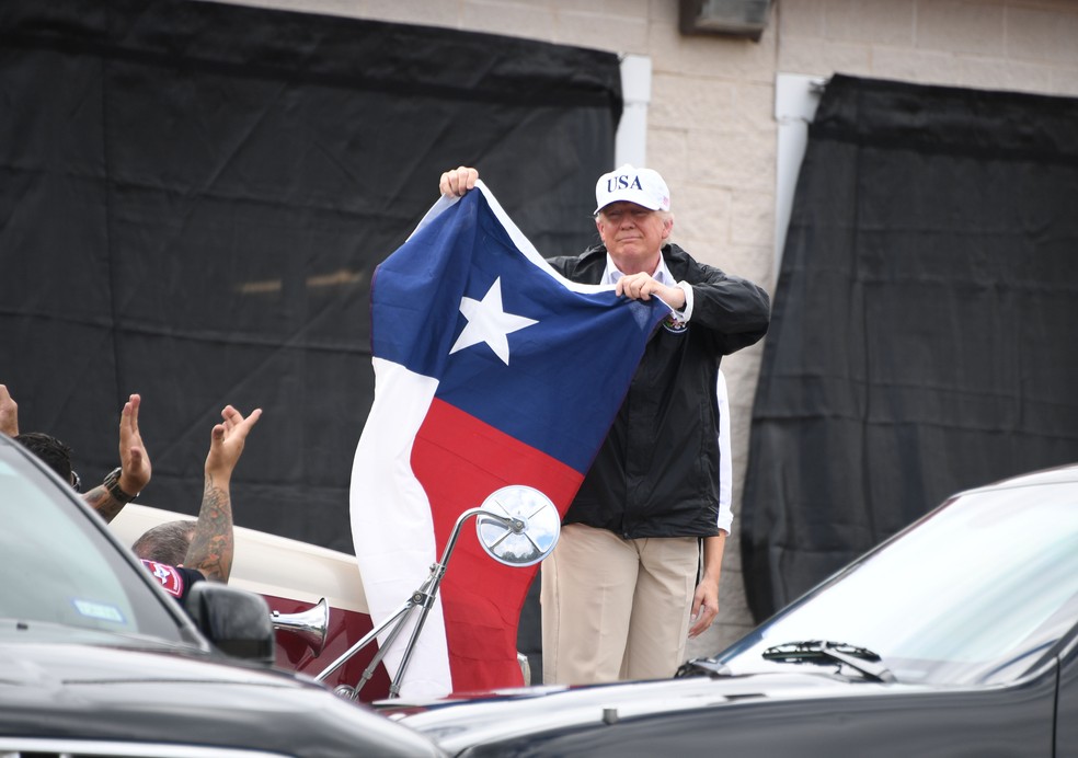  Donald Trump segura a bandeira do Texas após participar de reunião em Corpus Christi. Ele chegou à cidade nesta terça para avaliar os estragos causados pelo furacão Harvey (Foto: Jim Watson/AFP)