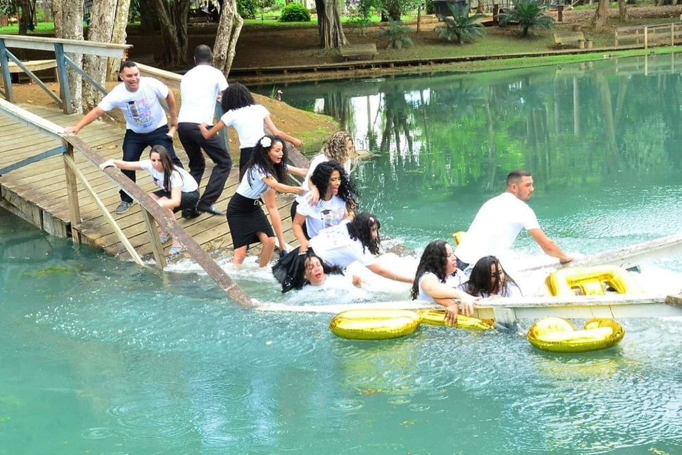 Alunos afundam em água após estrutura cair na sessão de fotos.  — Foto: Facebook/Reprodução