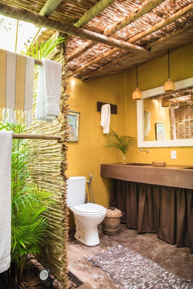 Decorado por Karin Farah, o banheiro tem um jardim interno e aberto ao tempo. A relação com a natureza e com elementos rústicos proporciona uma experiência sensorial marcante (Foto: Lufe Gomes / Editora Globo)