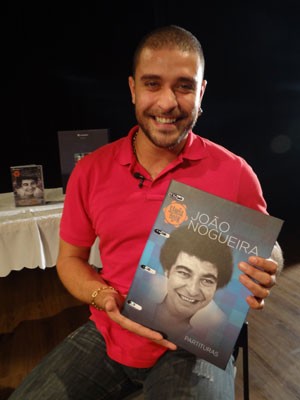 Artista segura discobiografia com partituras de João Nogueira (Foto: Luna Markman/ G1) Artista segura discobiografia com partituras de João Nogueira (Foto: Luna Markman/ G1)