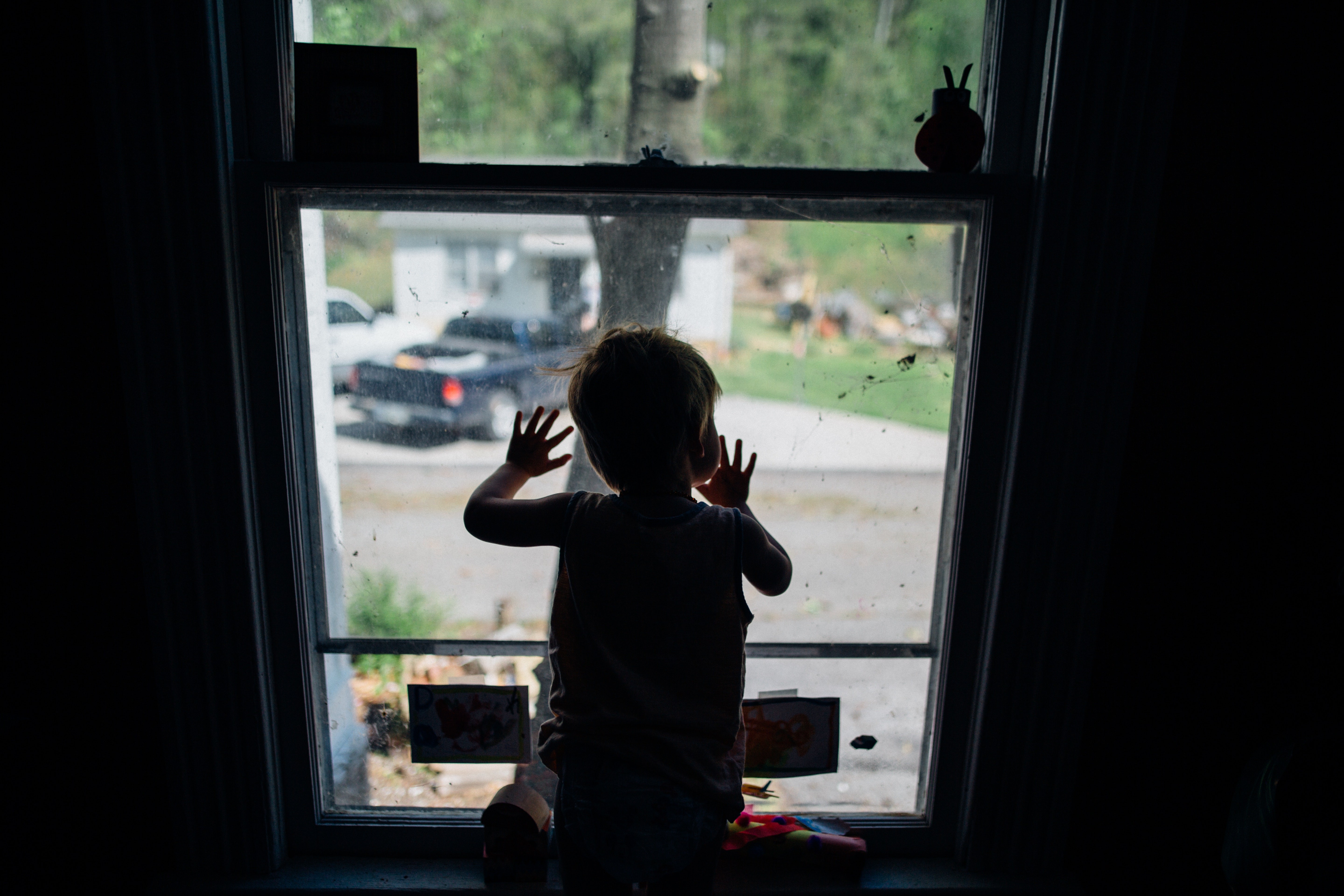 Criança sozinha em casa olhando pela janela (Foto: Kelly L/Pexels)