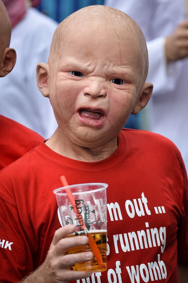 Homem 'encara' fotógrafo com máscara de bebê em Hong Kong (Foto: Philippe Lopez/AFP)