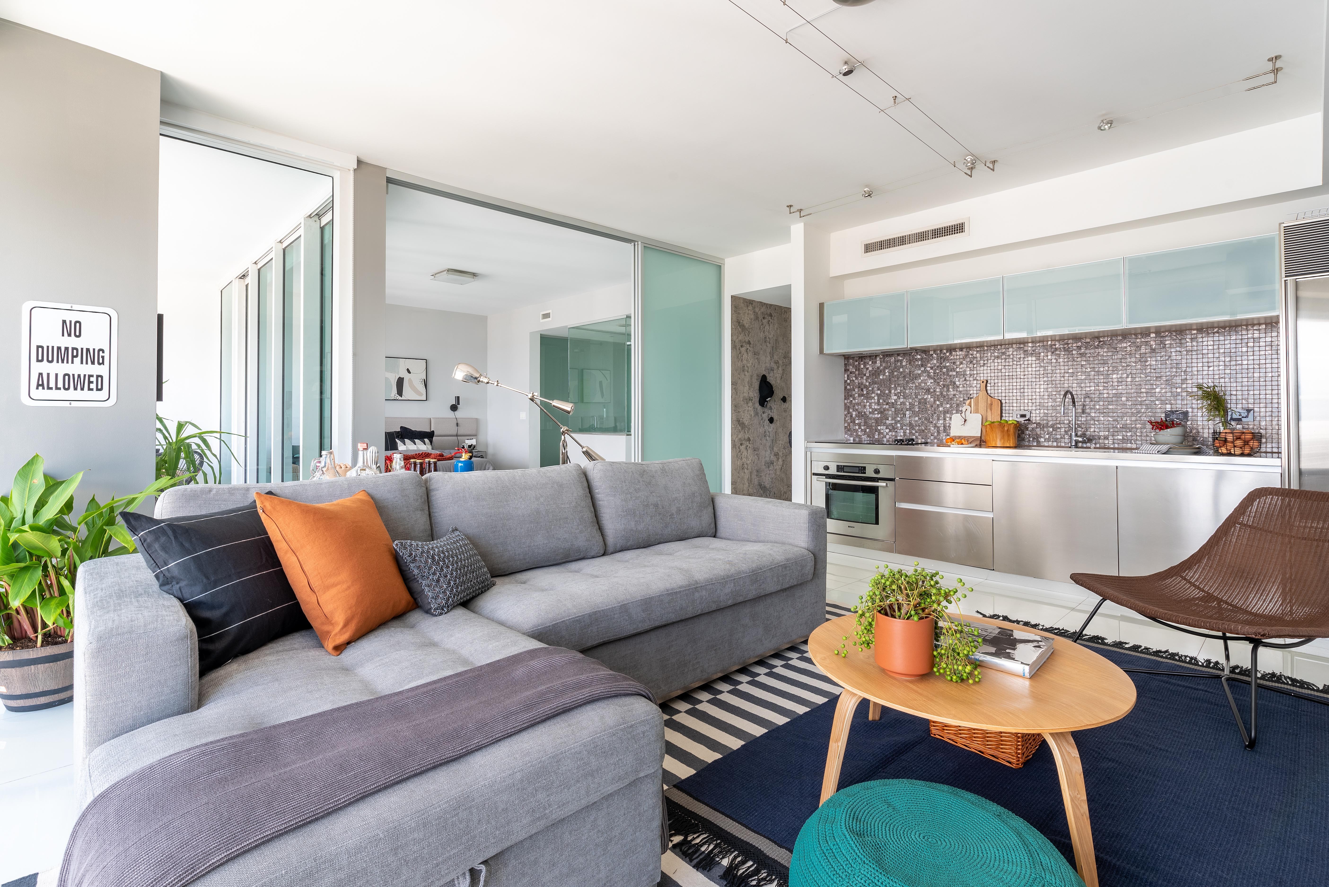 Living | O apartamento de 70 m² tem sala de tv, sala de estar e cozinha integrados. Os tapetes sobrepostos foram comprados na Ikea (Foto: Bethania Canavesi Photography / Divulgação)