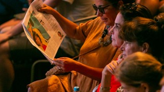 Público lendo o tabloide do GLOBO antes do início de uma das mesas do evento — Foto: Rebecca Alves / Agência O Globo