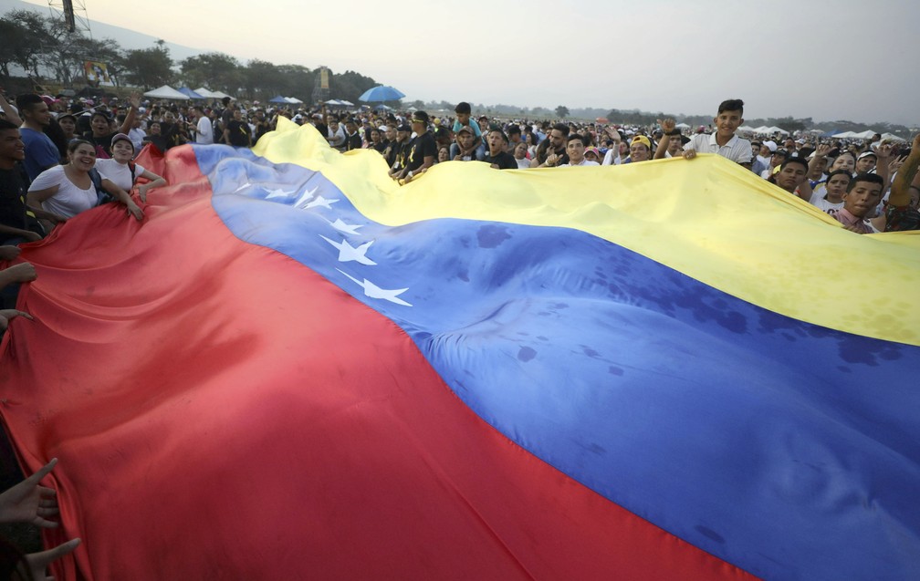 Multidão carrega bandeira da Venezuela durante show na fronteira do país com a Colômbia — Foto: AP Photo/Fernando Vergara