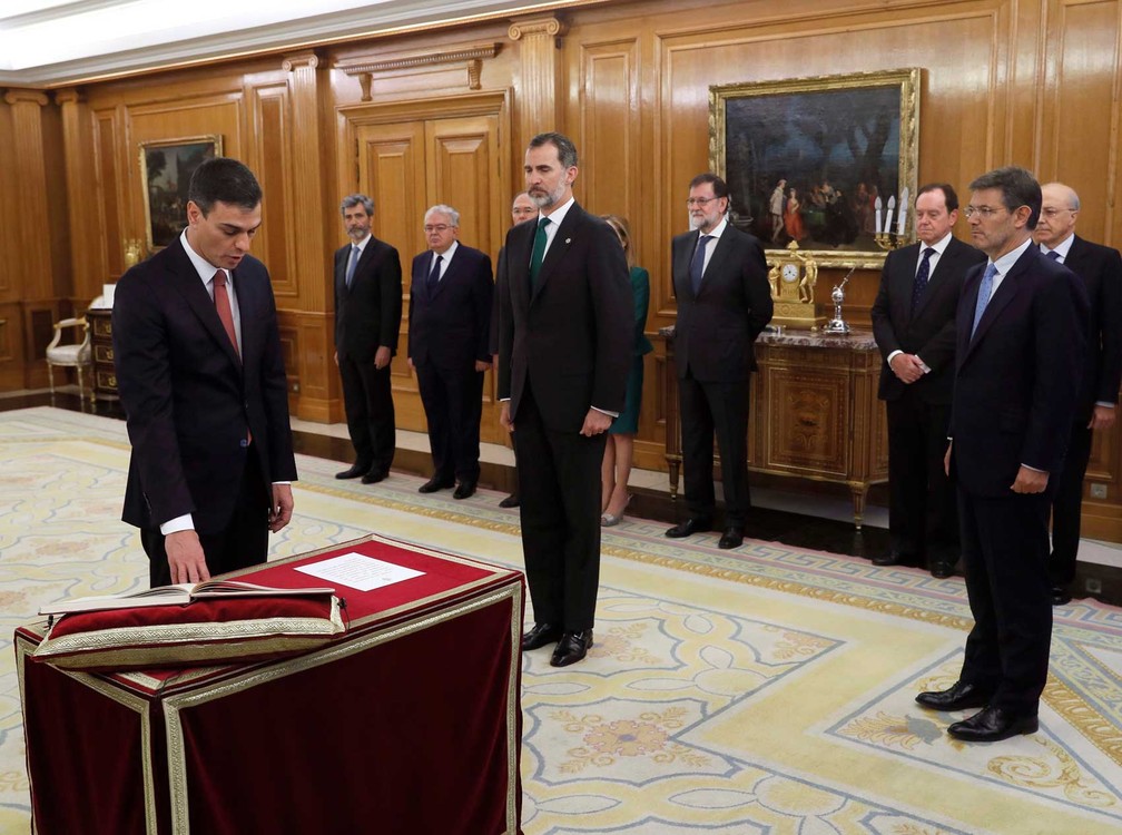 O líder socialista espanhol Pedro Sánchez faz o juramento durante a cerimônia de posse na presença do rei espanhol Felipe VI e do ex-primeiro-ministro Mariano Rajoy (Foto: Fernando Alvarado / Pool / via AP Photo)