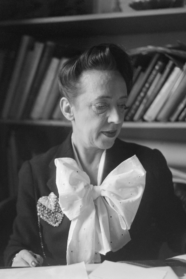 Elsa Schiaparelli with a brooch in the shape of a bunch of grapes, in the 1950s (Photo: Getty Images)