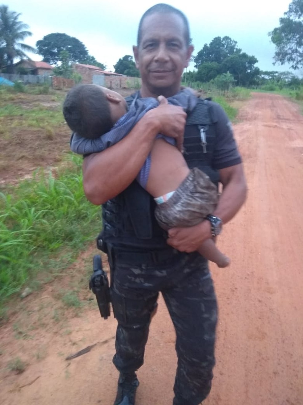 Policial segura uma das crianças que foi resgatada em Nova Lacerda — Foto: Gerência de Operações Especiais (GOE)