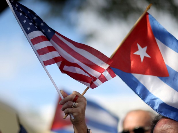 Manifestante segura bandeiras de Cuba e dos Estados Unidos (Foto: Joe Raedle/Getty Images)
