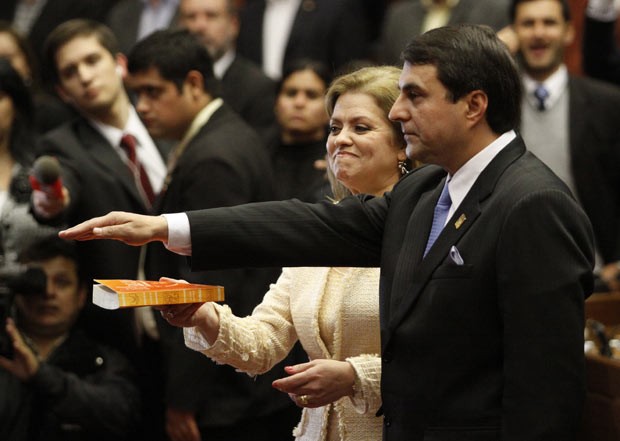 O novo presidente do Paraguai, Federico Franco, jura sobre a Bíblia, segurada por sua mulher, nesta sexta-feira (22) ao tomar posse em Assunção (Foto: AP)