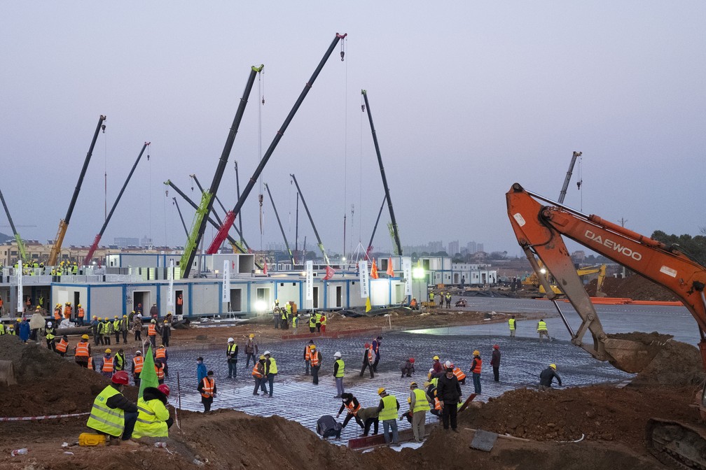 Dia e noite, trabalhadores atuam em obra de novo hospital Huoshenshan, em Wuhan (China). Construção feita com módulos pré-fabricados agiliza o início do funcionamento da nova unidade — Foto: Arek Rataj/AP Photo