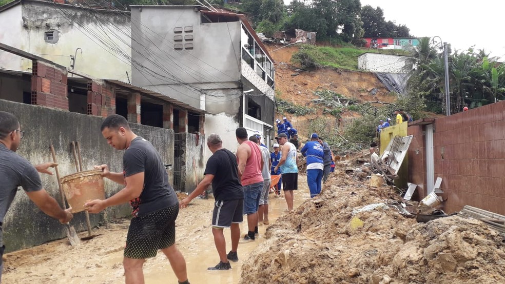 Moradores ajudam no trabalho de buscas por desaparecidos em Jardim Monte Verde, localidade mais atingida pelo deslizamento de barreira — Foto: Reprodução/TV Globo
