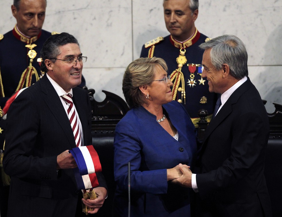 Michelle Bachelet cumprimenta Sebastián Piñera em cerimônia em que passou a faixa presidencial a ele em 2010 — Foto: Ivan Alvarado/Reuters