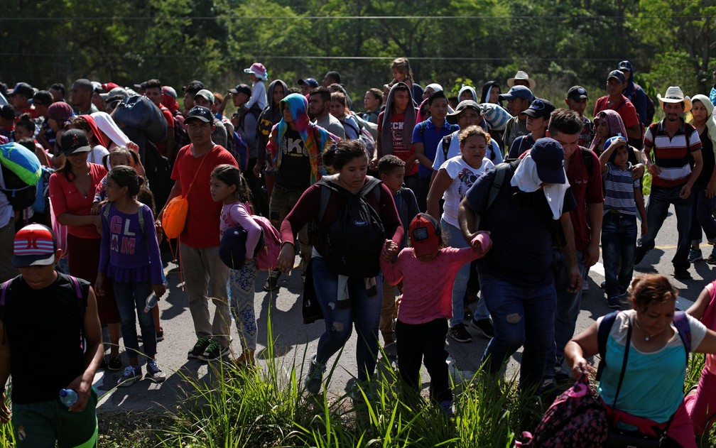 Migrantes hondurenhos caminham por Estrada em Metapa, no México, na sexta-feira (12) — Foto: Reuters/Jose Cabezas