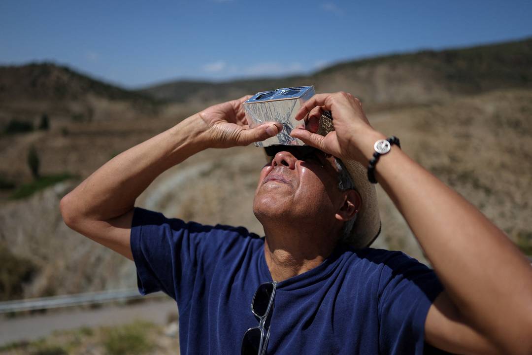 Cesar Gadea, de Miami, nos Estados Unidos, observa o Sol com um binóculo adaptado antes do eclipse solar total no Centro Galactica, perto do Observatório Astrofísico de Javalambre, em Arcos de las Salinas, na Espanha, nesta quarta-feira (12).