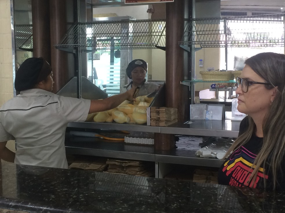 Zenir Silva olha a funcionária servindo pão em sua padaria. Ela já sentiu queda de mais de 50% do movimento menos de 24 horas após o anúncio de fechamento da Ford — Foto: Glauco Araújo/G1
