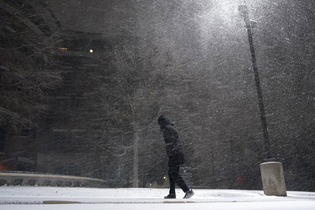 Mulher caminha pelas ruas de San Antonio, Texas (EUA), durante tempestade de neve no domingo (14) — Foto: Eric Gay/AP Photo