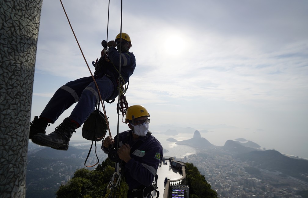 Alpinistas dão entrevistas pendurados durante manutenção do Cristo — Foto: Marcos Serra Lima