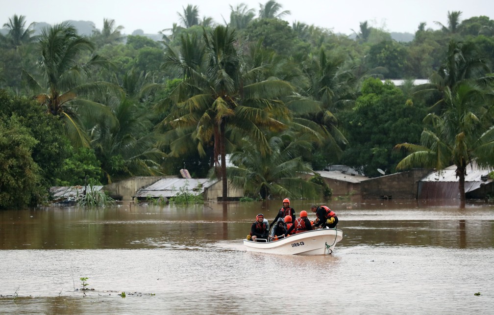 Equipe de resgate passa por casas submersas em um bairro inundado depois da passagem do ciclone Kenneth, em Pemba, Moçambique, neste domingo (28). — Foto: Mike Hutchings/Reuters