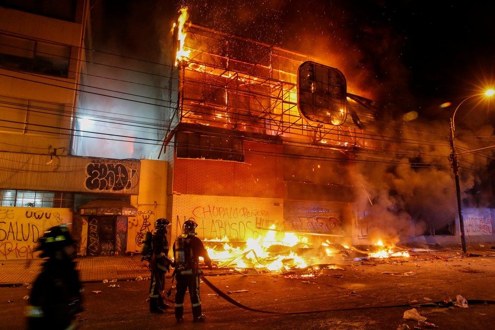 Bombeiros combatem incêndio durante protestos em Valparaíso, no Chile, no domingo — Foto: Reuters/Rodrigo Garrido