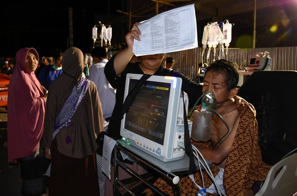 Paciente &eacute; levado para fora de pr&eacute;dio de hospital na ilha de Lombok ap&oacute;s terremoto que deixou pelo menos 82 mortos neste domingo (Foto: Antara Foto/Ahmad Subaidi via Reuters)