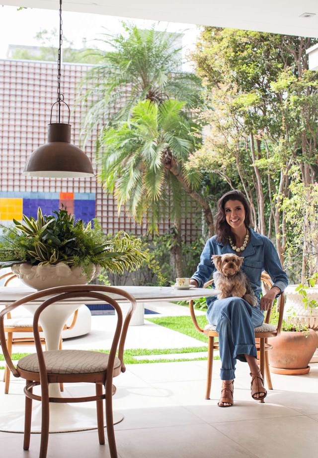 A designer posa na varanda vestindo Mixed, marca fundada pela família do marido (Foto: Divulgação)