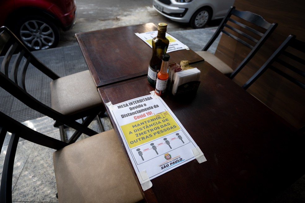 Bar na Zona Sul, em S&atilde;o Paulo, bloqueia alguns lugares com avisos sobre o distanciamento social &mdash; Foto: Marcelo Brandt/G1