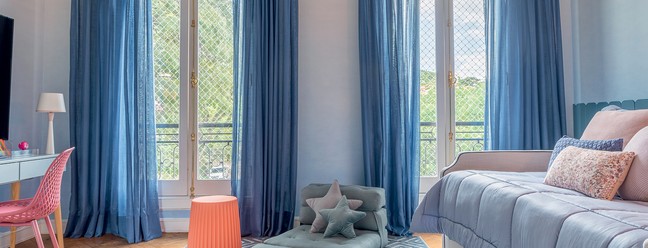Como a incidência de luz é generosa no quarto de Catarina, 10 anos, a arquiteta Barbara Jalles usou uma cortina de veludo em tom de azul mais intenso. Pufe da Deezign e tapete da Doural  — Foto: Rafael Renzo/Divulgação