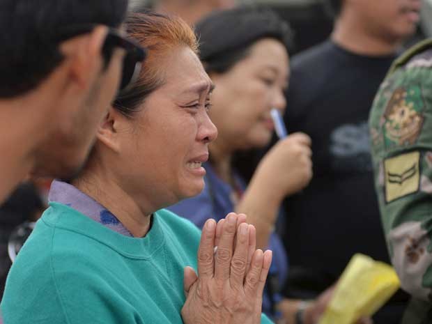 Parente de vítima de naufrágio reza e chora nas Filipinas (Foto: Alan Kristofer Motus / Reuters)