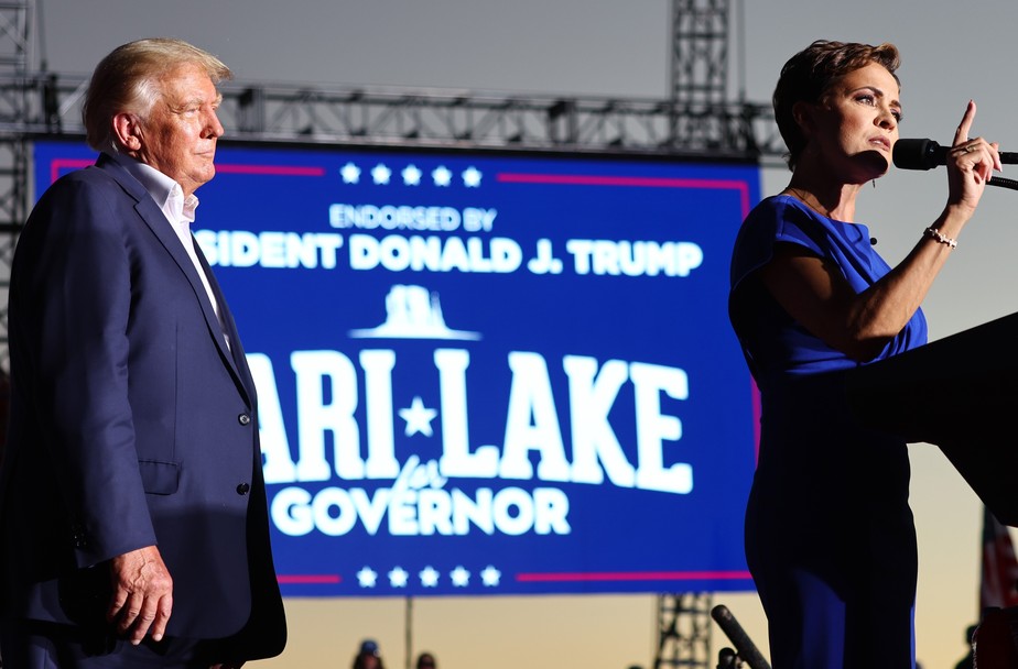 Candidata republicana ao governo do Arizona, Kari Lake, é observada pelo ex-presidente Donald Trump durante discurso