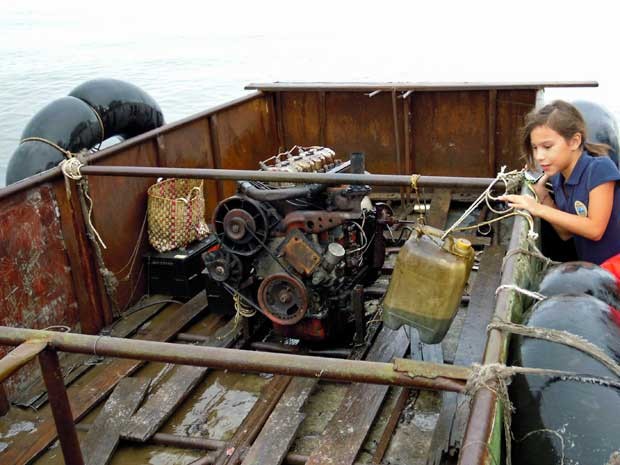 Menina observa embarcação que tinha um motor de trator como propulsor. (Foto: David Adams / Reuters)