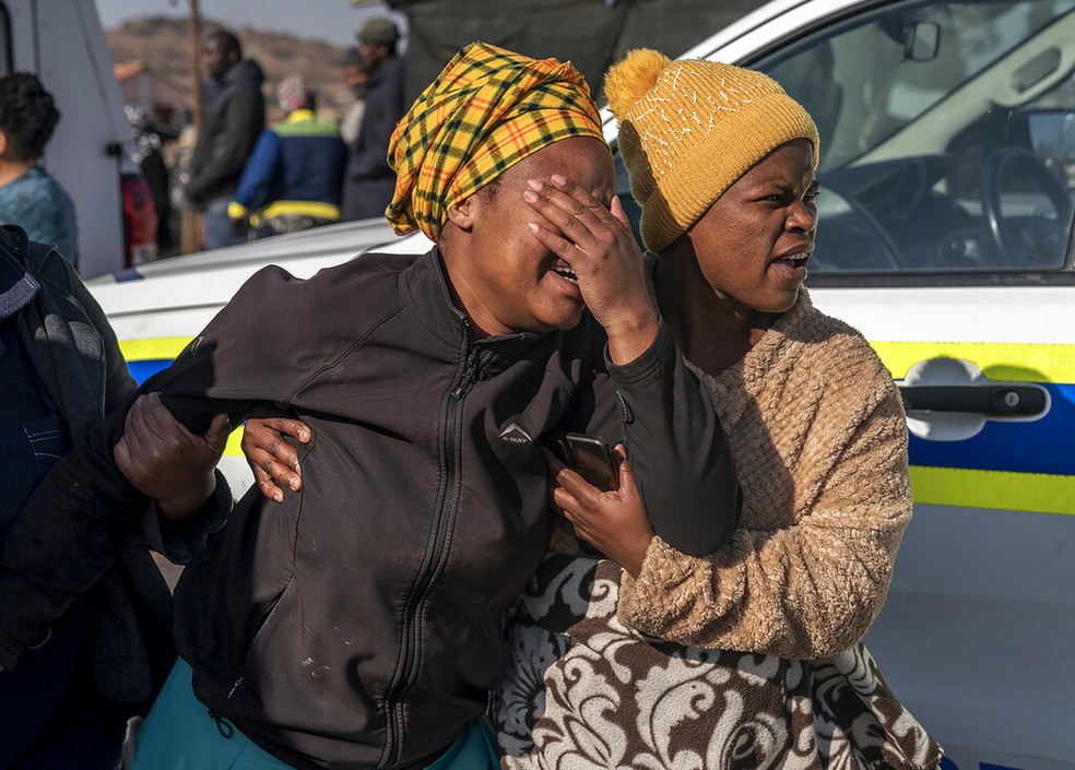 Mulher chora em cena de crime em Soweto, na África do Sul, em 10 de julho de 2022 — Foto: Shiraaz Mohamed/AP